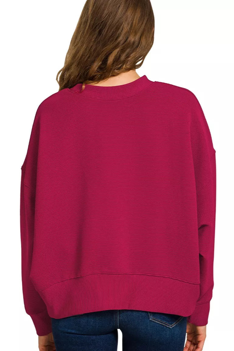 Person wearing a magenta sweater on a white background, Sarah express