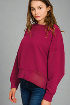 Woman wearing a cabernet sweater on a white background