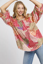 Sarah Express women’s oversized boho peasant blouse with a whimsical feather print and flowy sleeves.
